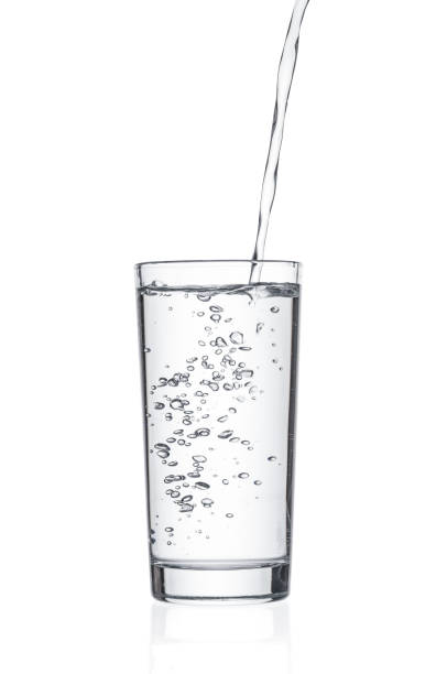 istock Flowing pure water into tumbler on white background 1206249680