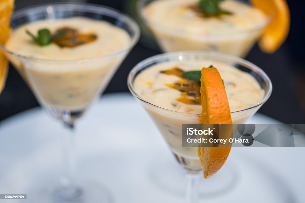 Bright passion fruit mousse decorated with orange slice A martini glass filled with a dessert of passion fruit mousse decorated with orange slice Passion Fruit Stock Photo