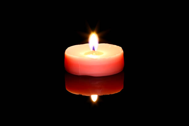 One pink tea light candle isolated on black glass with reflection
