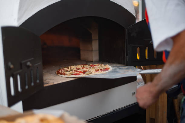 istock Baker puts the fresh pizza in the oven 1206252096
