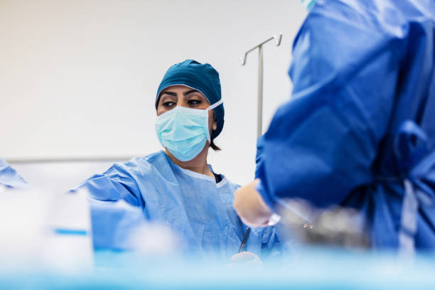 cirurgião pega um instrumento cirúrgico - nurse reaching women doctor - fotografias e filmes do acervo