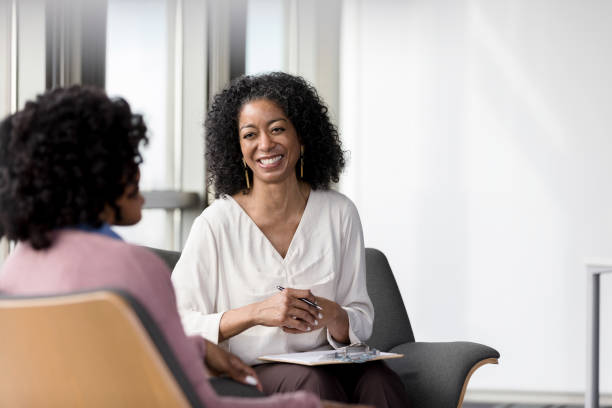 istock Female therapist smiles broadly as unrecognizable client speaks 1206255540