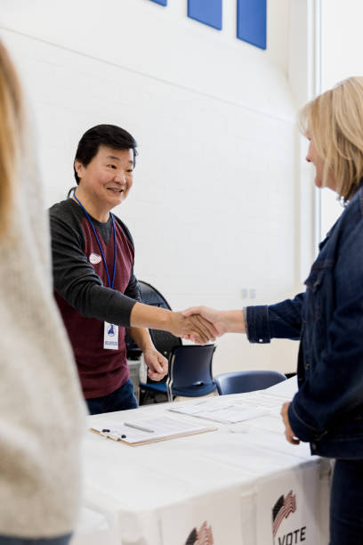 istock Friendly polling place volunteer greets voter 1206255602