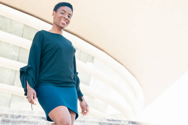 istock Joyful female employee leaving office building 1206255967