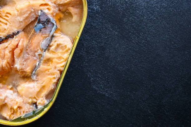 canned salmon, fish preserves (seafood in a tin can) menu concept background. top view. copy space