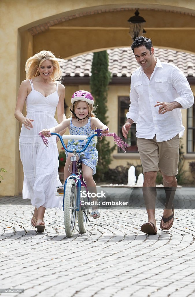 Famille avec la fille vélo équitation & heureux Parents - Photo de Faire du vélo libre de droits