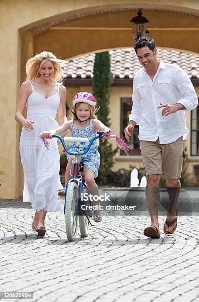 Família Com Menina Na Bicicleta De Equitação Feliz Pais - Fotografias de stock e mais imagens de Ciclismo