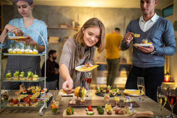 istock Beautiful young woman taking food during after work dinner party 1206259992