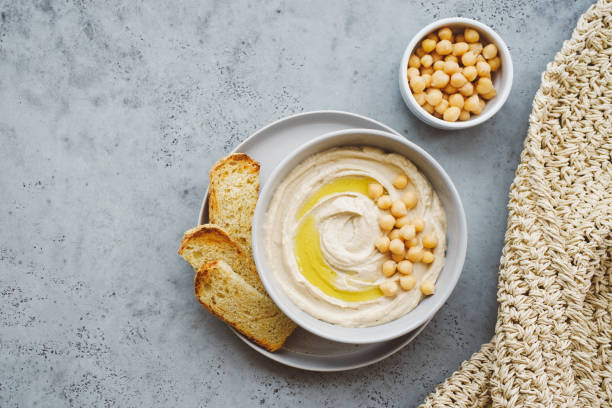Hummus plate with olive oil and chickpeas. Gray background. Copy space