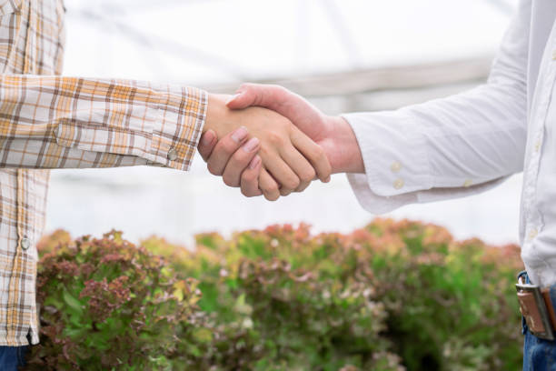 landwirte und geschäftsleute, die die hände halten. - business document achievement farm stock-fotos und bilder