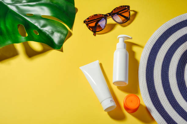 istock Sunprotection objects. Woman's hat with sunglasses and protection cream SPF Flat lay on yellow background. Beach accessories. Summer Travel Vacation Concept 1206262782