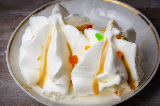 istock Close-up ice cream sundae with colored fruit slices on a white plate . 1206267820