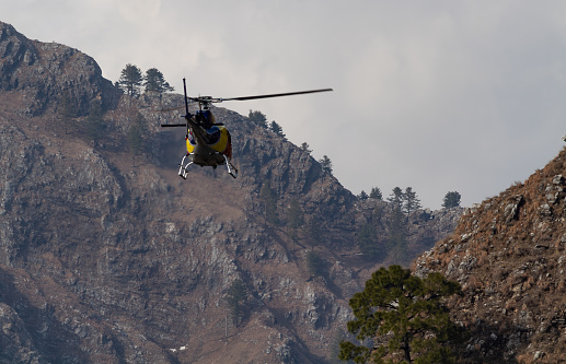 A Chopper flying from between mountain valley in rescue operation concept