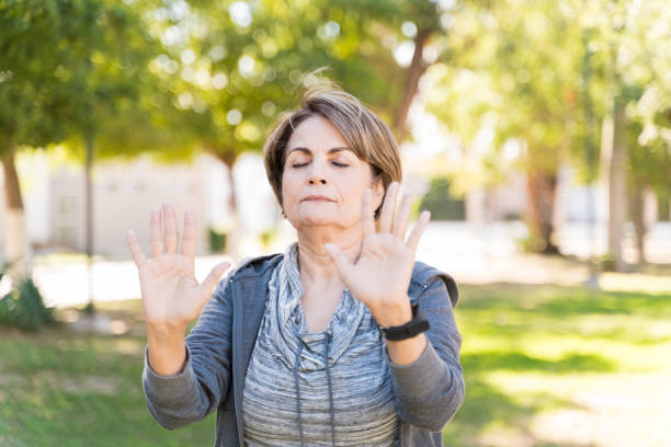 istock Retired Active Woman Meditating With Arms Raised 1206280790