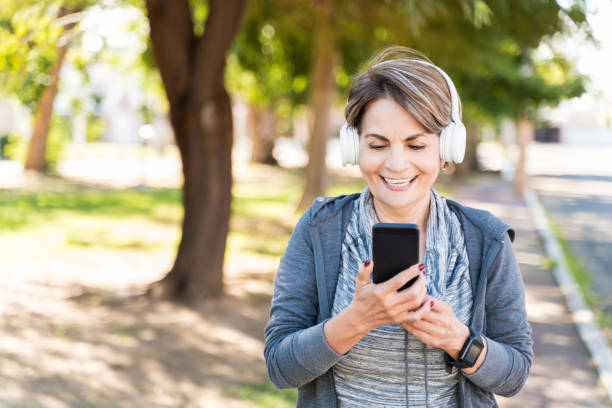 istock Happy Senior Woman Using Smartphone In a park 1206281711