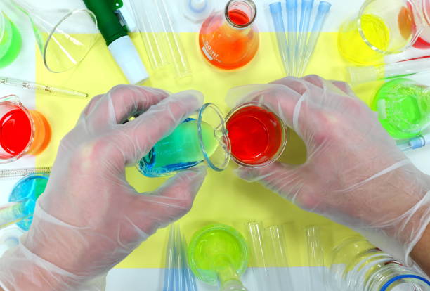 istock Scientist hands working on colorful chemicals flat lay. Chemistry Science Laboratory Class 1206282021