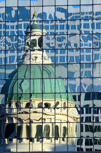 The dome of the Old Courthouse in St Louis, Missouri is reflected in a modern skyscraper.