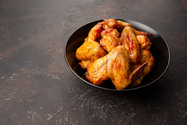 istock Chicken BBQ wings in black plate on dark background 1206284612