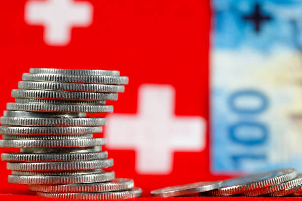 swiss coins with a background of a banknote - swiss francs swiss currency switzerland finance imagens e fotografias de stock