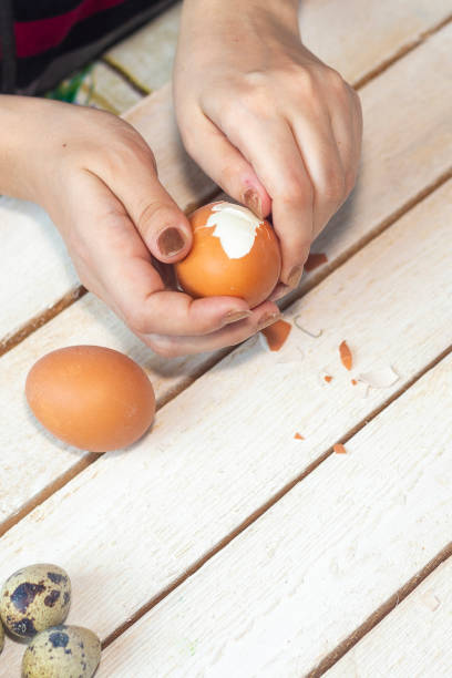 istock Woman cleaning boiled eggs from the shell 1206294141