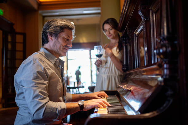 istock Romantic man playing a piano for a young woman at a restaurant 1206295145