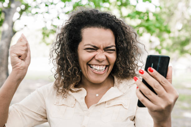 istock Cheerful woman using smartphone in city park 1206295204