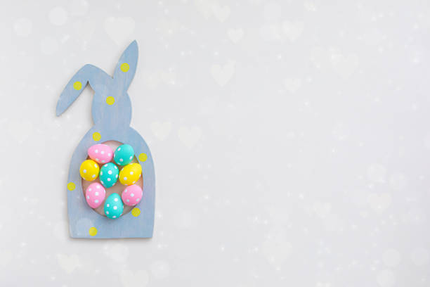 istock Composition of Easter bunny rabbit frame and colorful eggs on beige background, flat lay 1206301004