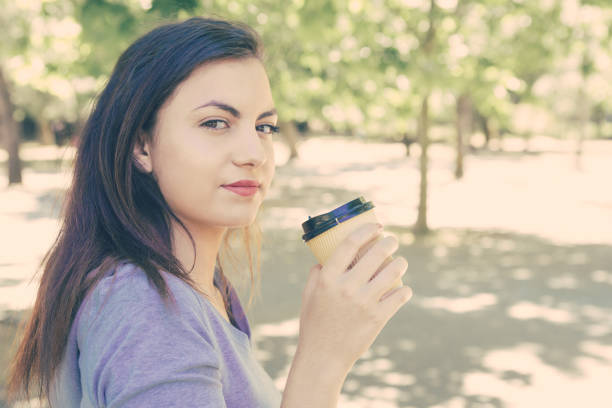 Woman drinks coffee on the street. Woman drinks tea. Woman drinks coffee outdoor. Businesswoman drinks coffee outdoor. Man drink coffee in cafe.Cozy atmosphere. Student sip hot cocoa or Cappuccino.