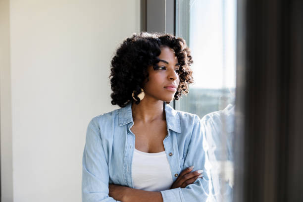 istock Beautiful woman looks through window 1206311559
