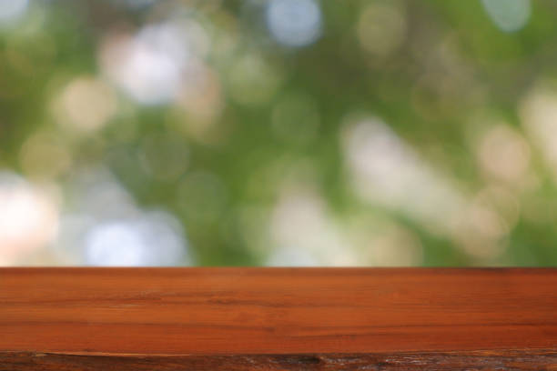 istock Empty wooden table in front of abstract blurred green bokeh light of trees and nature light background. For montage product display or design key visual layout - Image 1206315549