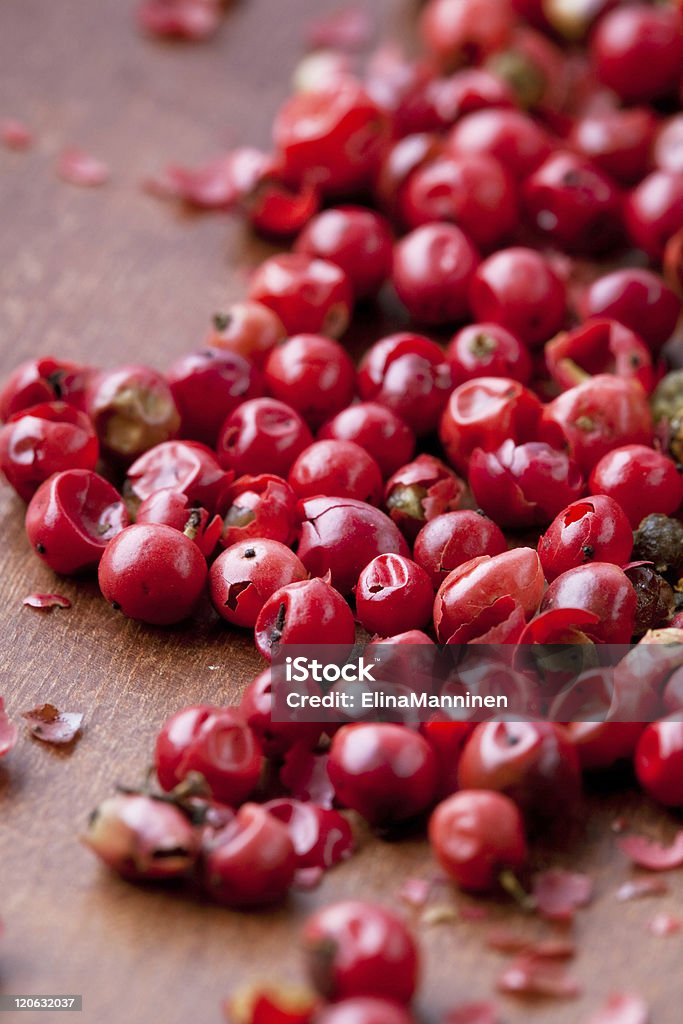 Red peppercorns Close-up of red peppercorns on a wooden background Backgrounds Stock Photo