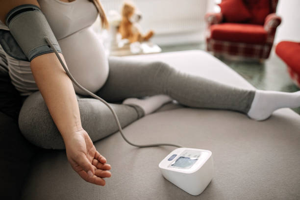 беременные женщины, измеряя кровяное давление - blood pressure gauge surveillance home interior house стоковые фото и изображения