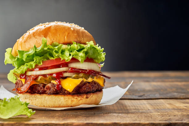 Juicy hamburger on dark wooden table