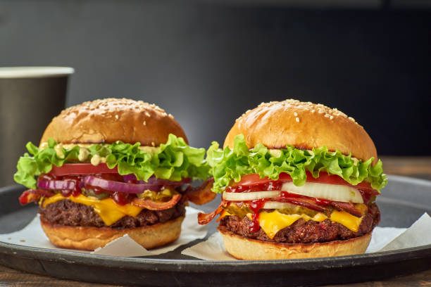 two hamburgers and paper cup of drink on dark background - salad food and drink food lettuce imagens e fotografias de stock