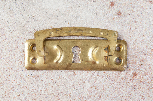Antique brass drawer pull knob on concrete background. Copy space for text.