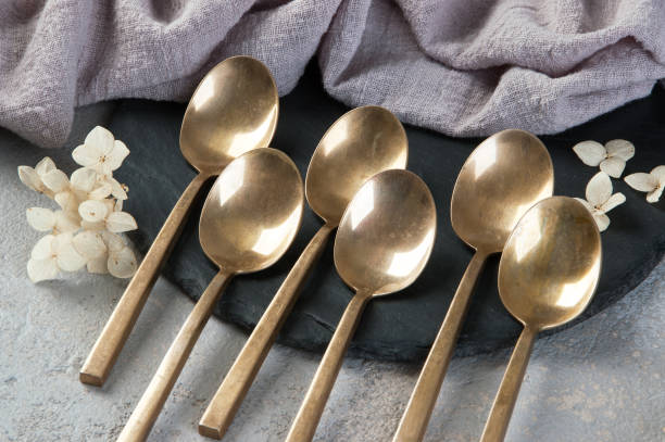 istock Old bronze tea spoons on concrete 1206326944