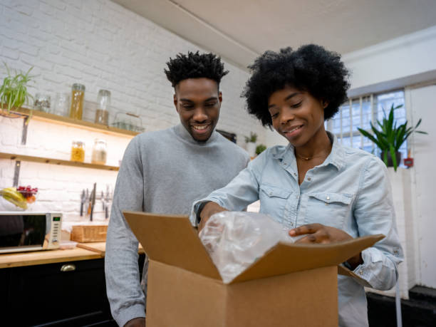 istock Black couple receiving a parcel at home 1206327565