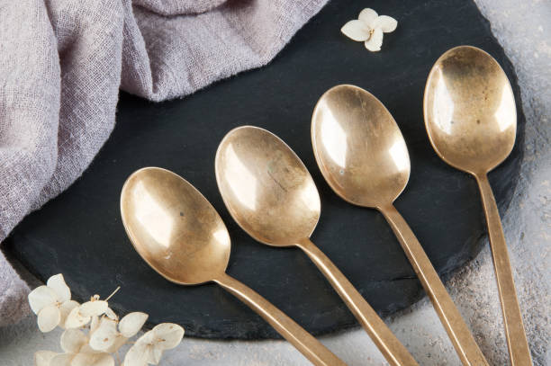 istock Old bronze tea spoons on concrete 1206327760