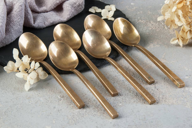 istock Old bronze tea spoons on concrete 1206328058