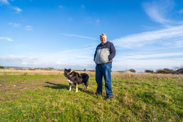 istock Man walking on grassland with border collie 1206331563
