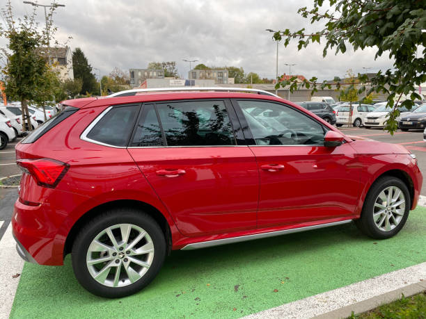 Side view of new family executive business red Skoda SUV offroad car in front of new dealership car dealer showroom Paris, France - Oct 25, 2019: Side view of new family executive business red Skoda SUV offroad car in front of new dealership car dealer showroom car transporter truck small car stock pictures, royalty-free photos & images