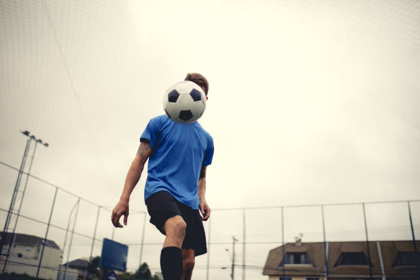 istock Young man ball juggling at soccer field 1206334689