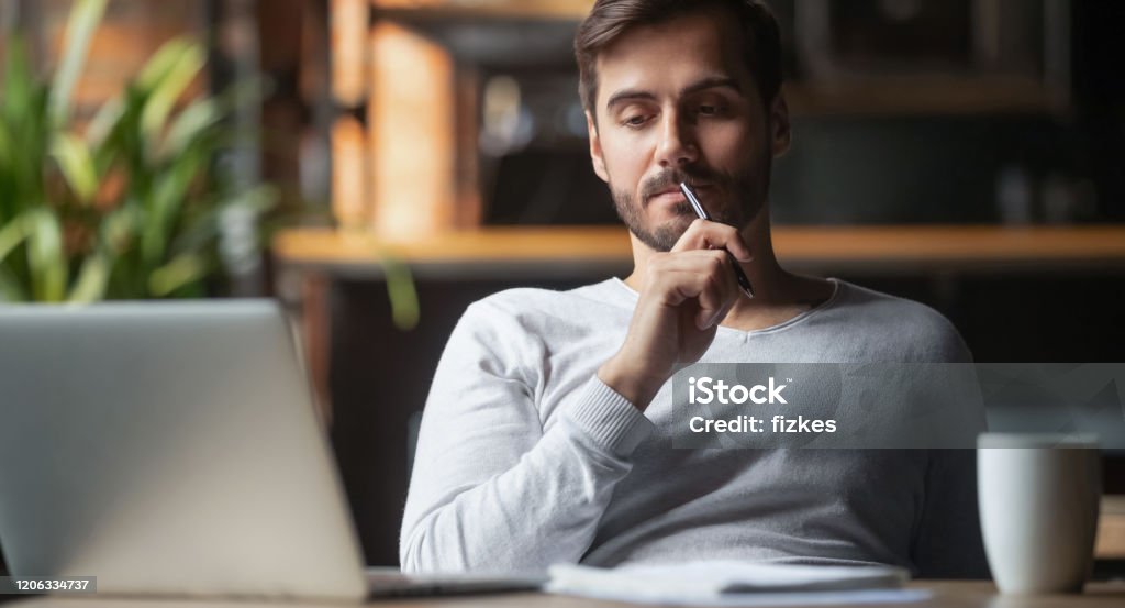 Pensive male thinking over problem solution working on laptop Pensive bearded man sitting at table drink coffee work at laptop thinking of problem solution, thoughtful male employee pondering considering idea looking at computer screen making decision Contemplation Stock Photo Pensive male thinking over problem solution working on laptop Pensive bearded man sitting at table drink coffee work at laptop thinking of problem solution, thoughtful male employee pondering considering idea looking at computer screen making decision Contemplation Stock Photo