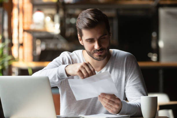 istock Male student open postal letter from college committee 1206334745