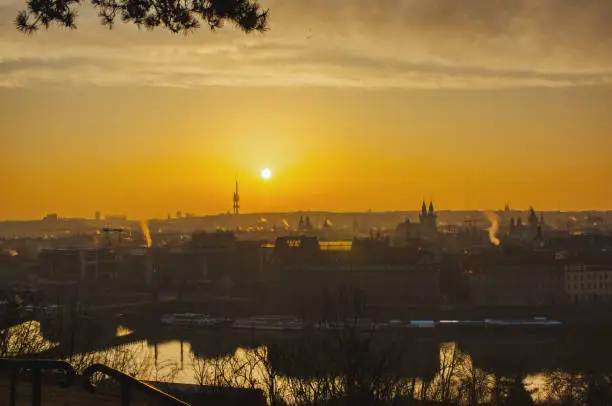 Photo of prague tv tower at sunrise wirh roofs and birds flying