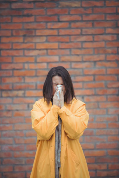 istock Sick young woman blowing her nose 1206335696