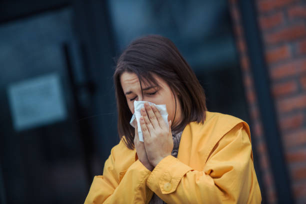 istock Sick young woman blowing her nose 1206335701