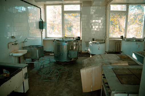Abandoned and ruined kitchen of closed factory canteen or restaurant.