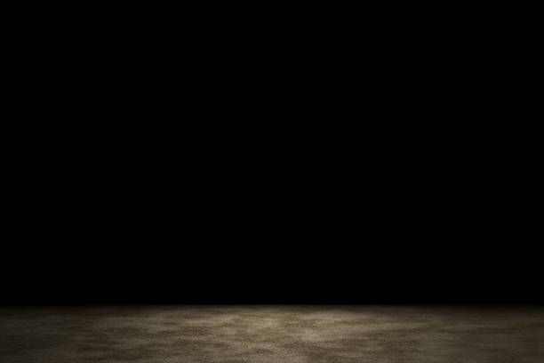 istock Light shining down on brown sand floor in dark room with copy space, abstract background 1206343733