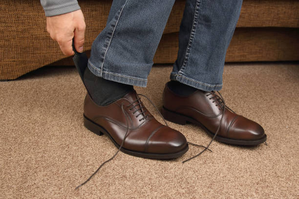 istock Man tying shoelaces on classic brown shoes 1206345102